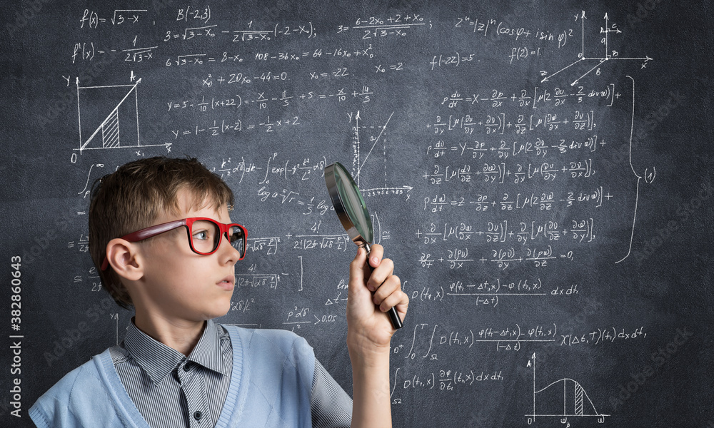 Curious school boy with magnifier