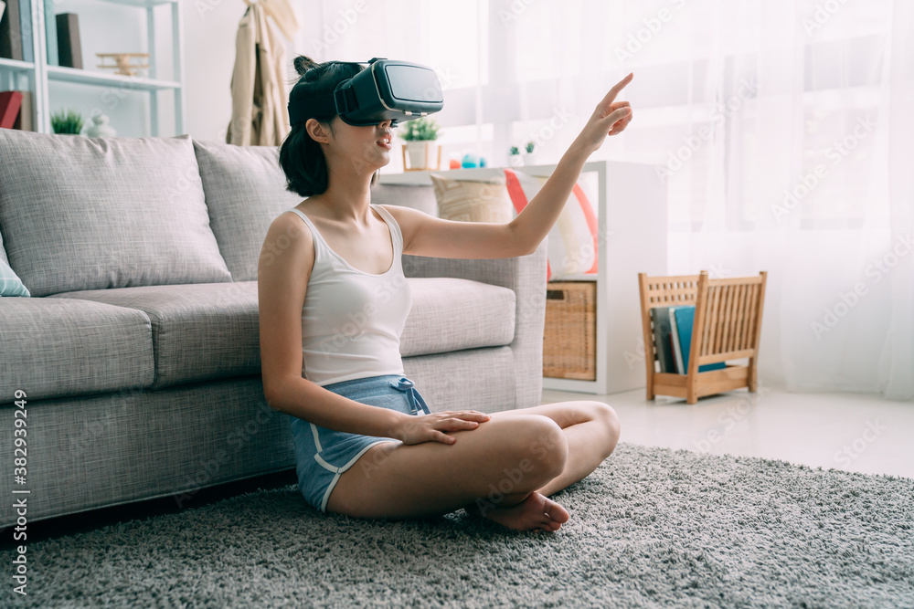 young cute asian japanese woman sit on carpet at home wearing virtual reality headset in home living