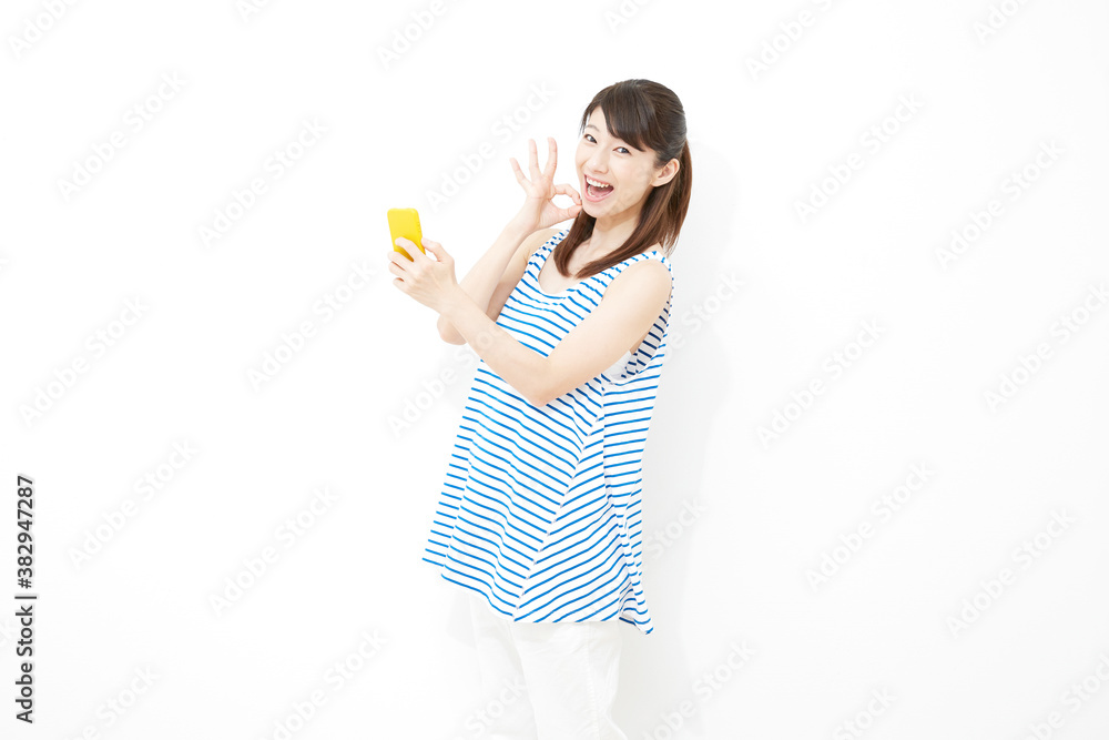 スマートフォンを持ってOKする女性