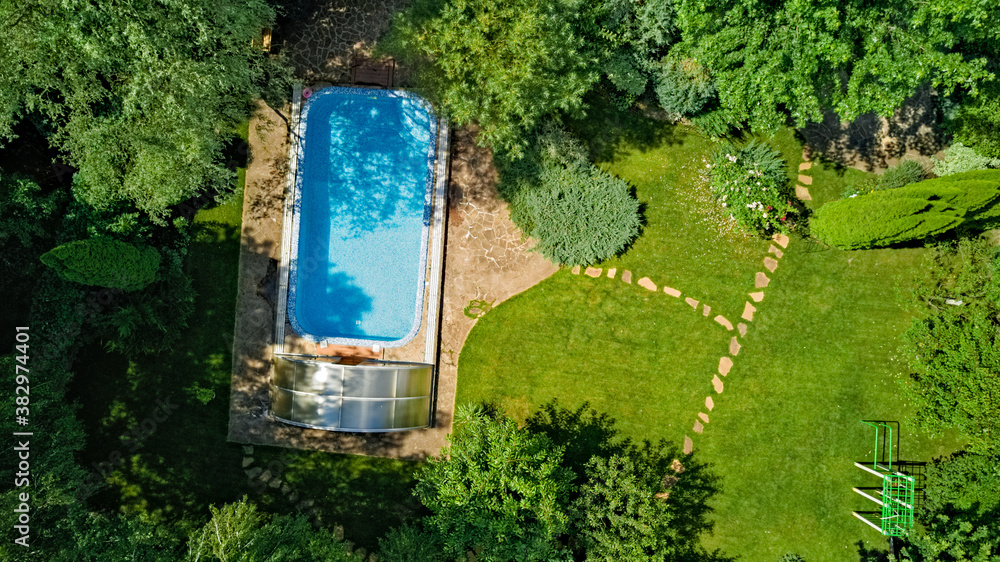 Swimming pool in beautiful garden aerial top view
