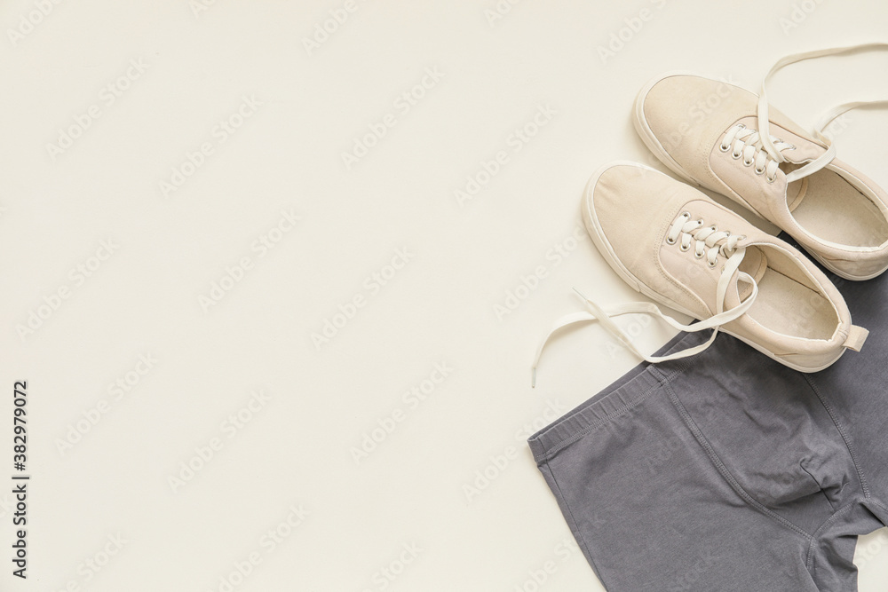 Stylish male trunks and shoes on white background