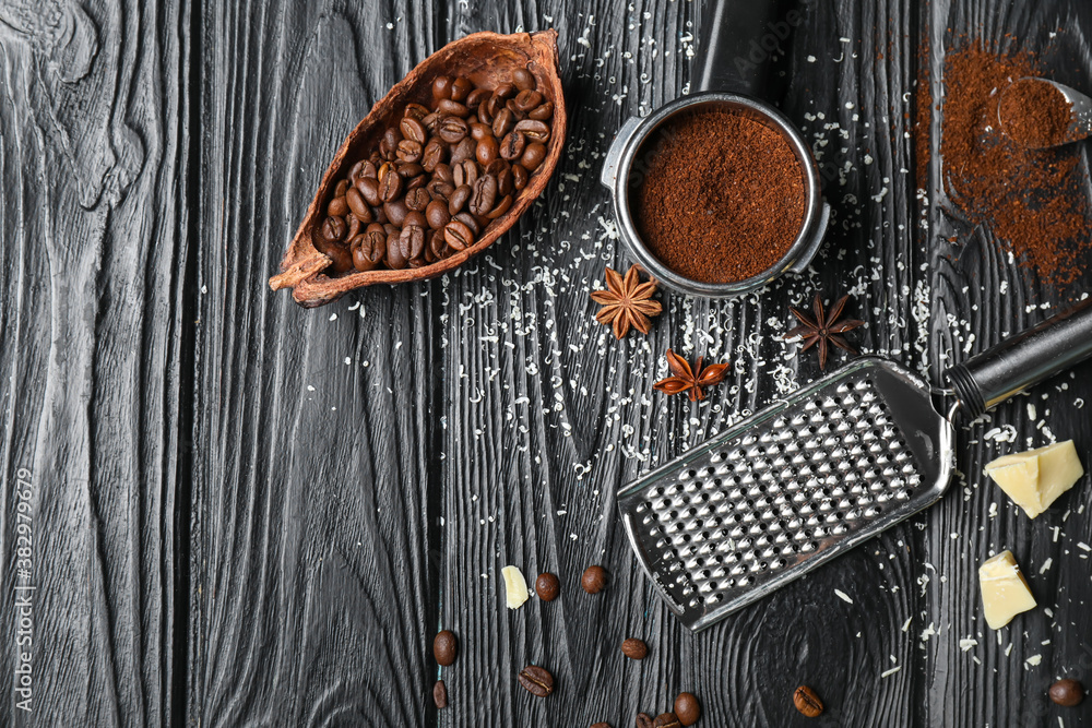 Portafilter with coffee powder, cacao pod and grinder on dark wooden background