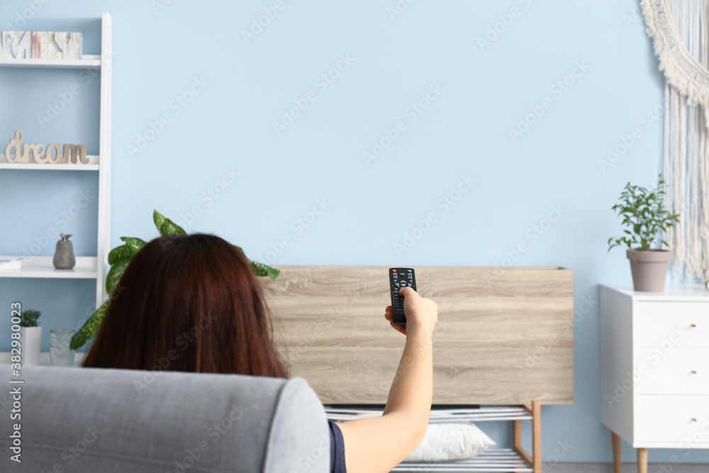 Young woman watching TV at home