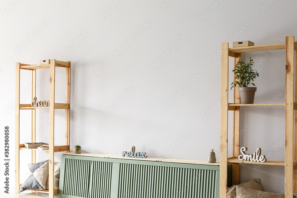 Stylish interior of room with stand and wooden racks