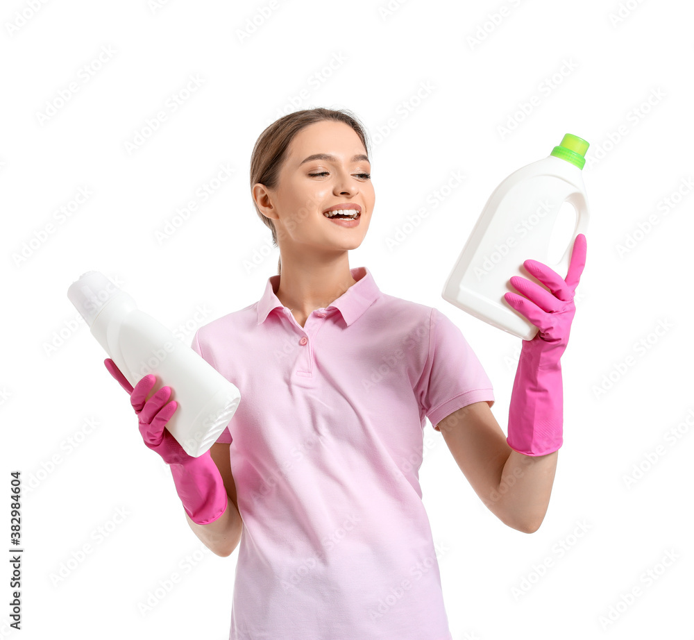 Young woman with cleaning supplies on white background