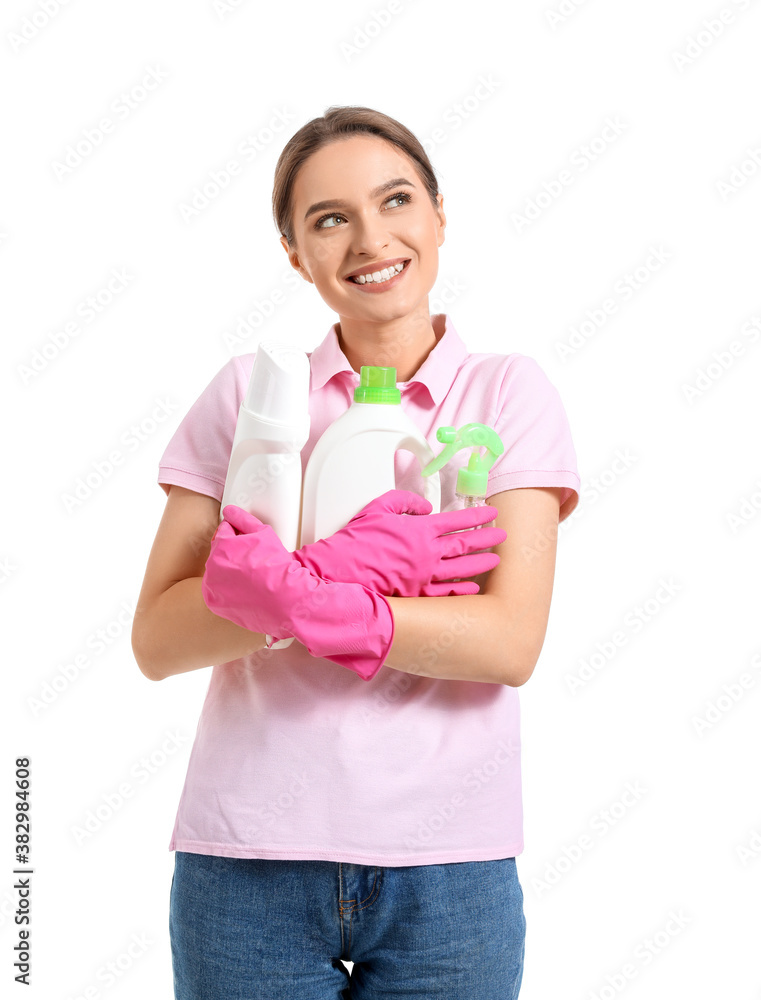 Young woman with cleaning supplies on white background