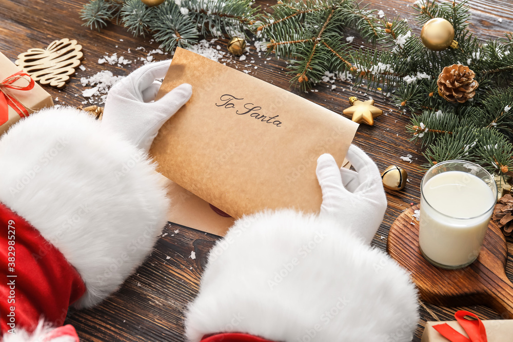 Santa Claus reading letter at table