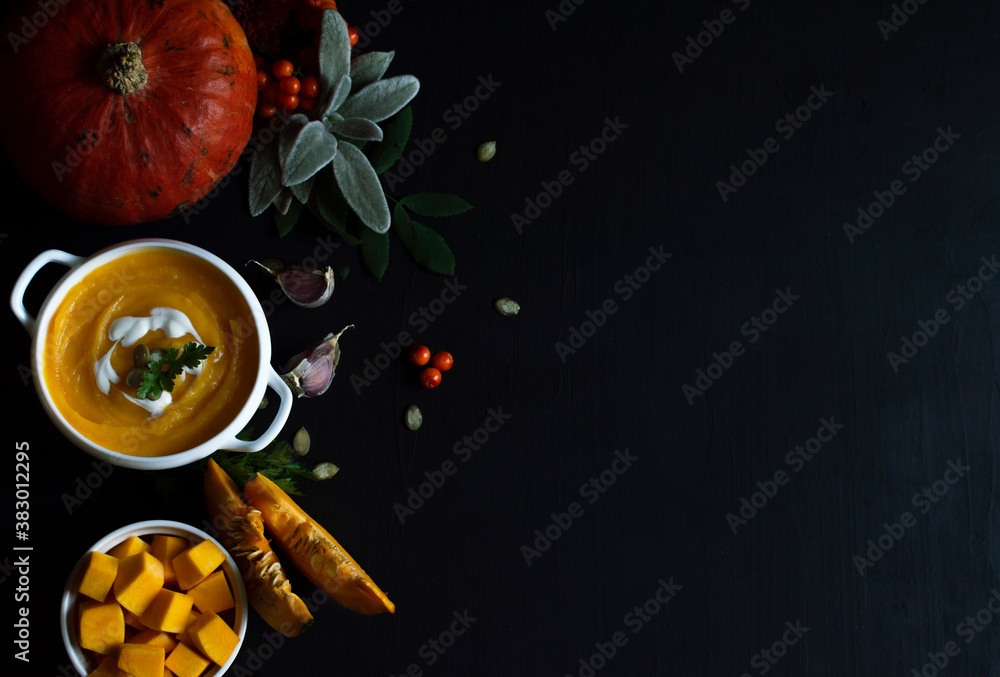 Vegetarian autumn pumpkin cream soup with seeds in white bowls on a dark background.The concept of h