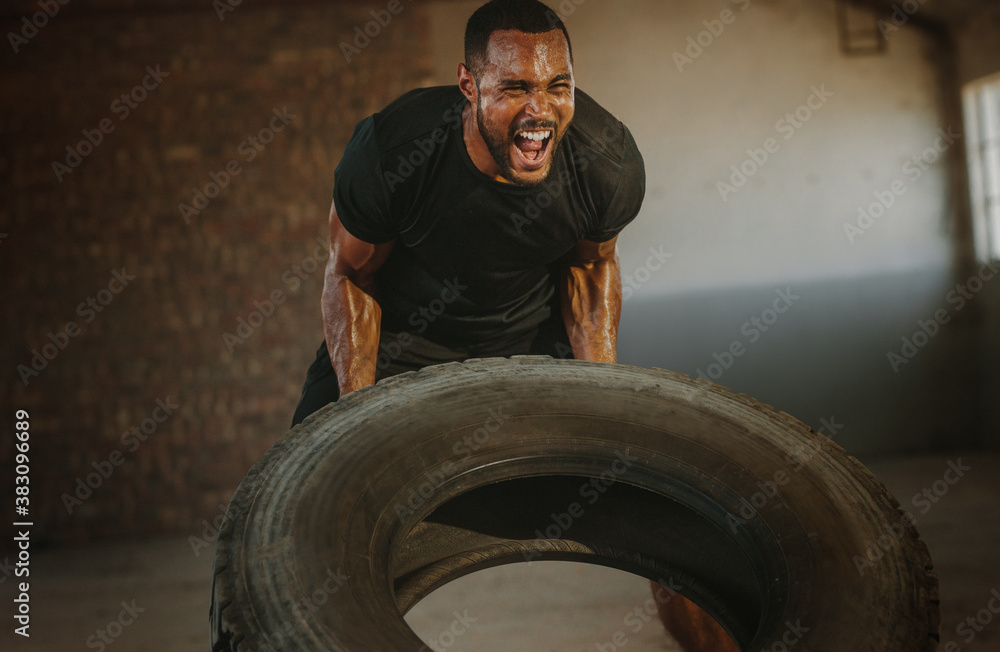 Strong man doing heavy tire flip exercise