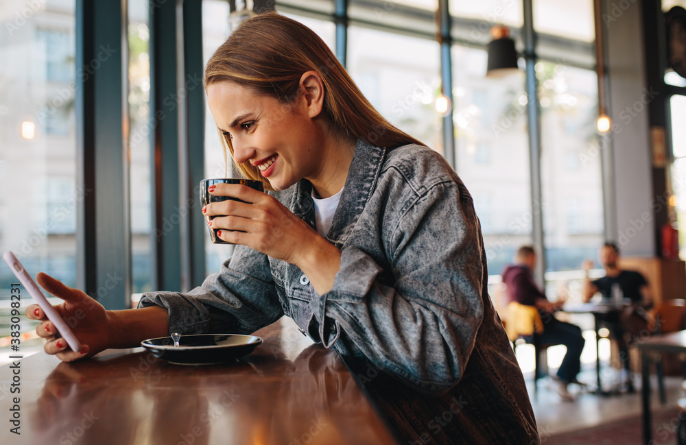 Woman using phone at coffee shop