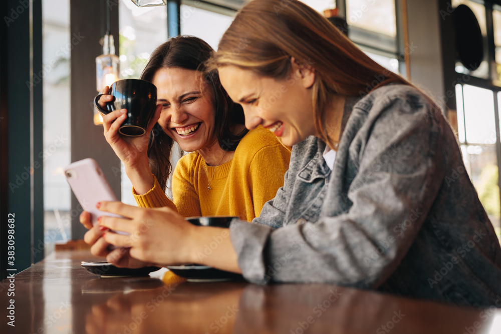 Two friends having fun at a coffee shop