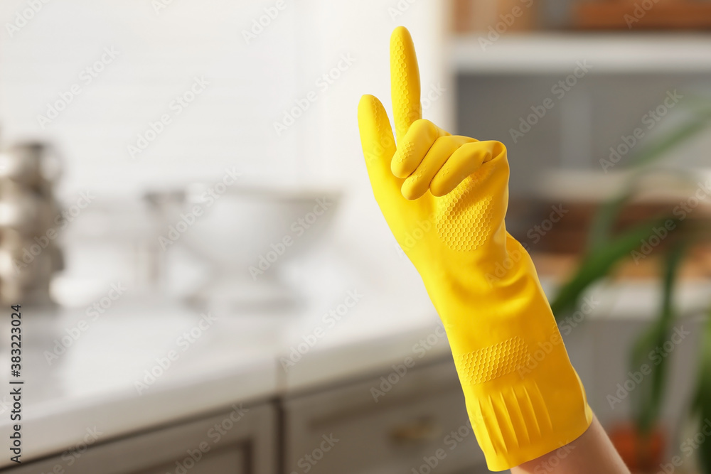 Hand of woman in rubber glove in kitchen