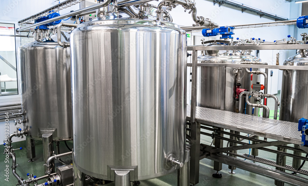 Dairy production. Apparatus for bottling milk products. Steel tanks at milk factory.