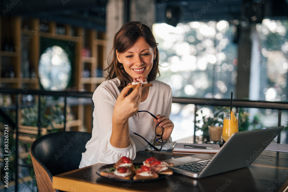 Business woman eating at restaurant.