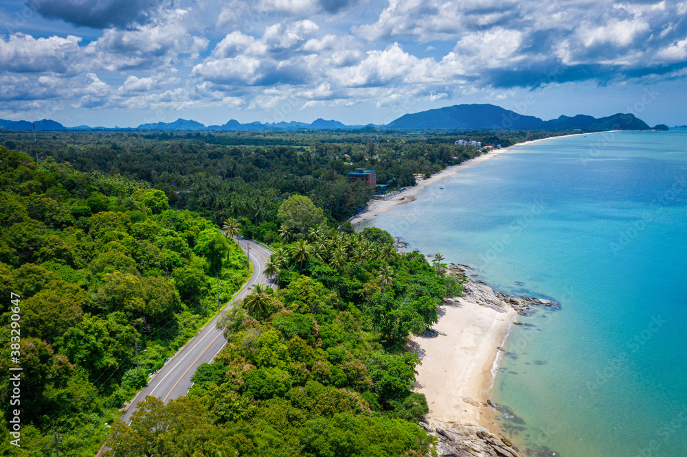 Aerial view of road between coconut palm tree and great ocean at daytime in Nakhon Si Thammarat, Tha