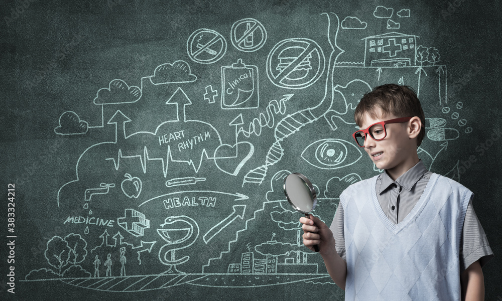 Curious school boy with magnifier