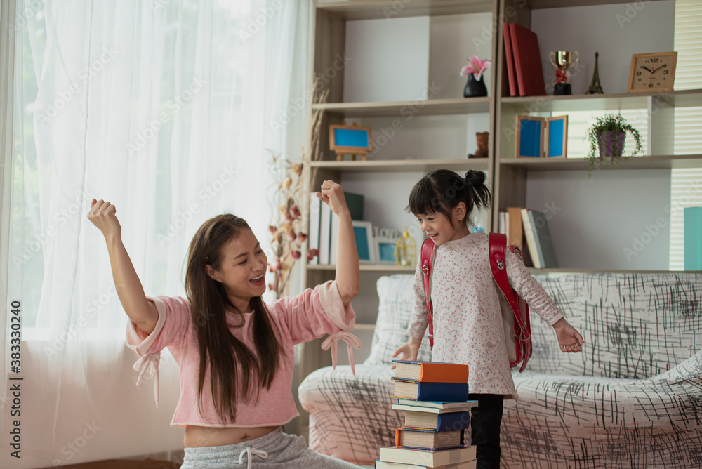 Adorable young mother and daughter preparing backpack for school, Happy Asian family