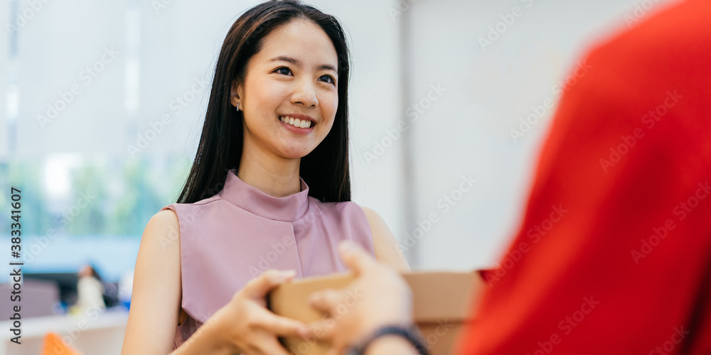 Happy Asian businesswoman taking pizza boxes from pizza delivery man, lunch break, takeaway pizza de