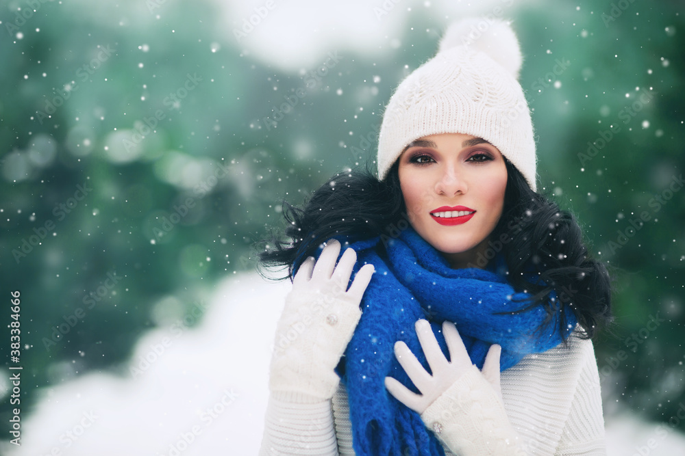 Outdoors lifestyle image of stunning young woman walking in the snowy spruce forest. Smiling and enj