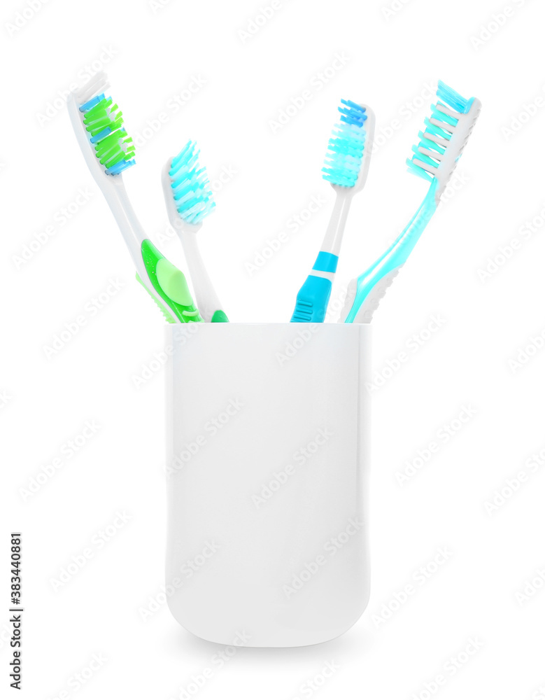 Cup with tooth brushes on white background