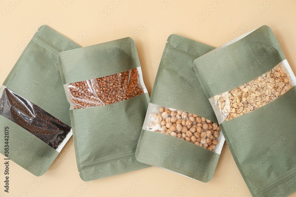 Bags with different groats on color background