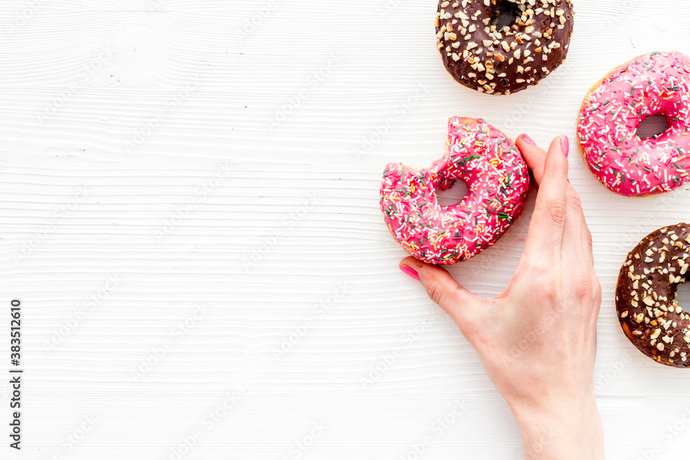 Hand holding glazed donut swith sprinkles, above view