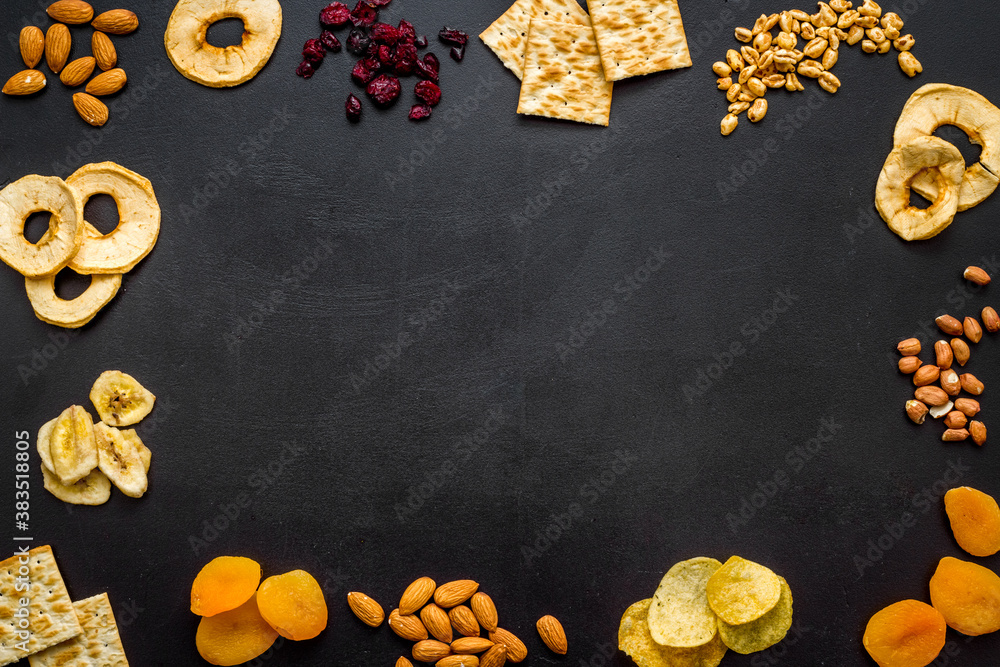 Snacks mix frame top view. Nuts and dried fruits with crackers, copy space