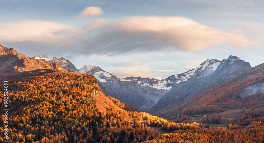 Atumn mountains near lake Sils (Silsersee) in Swiss Alps. Colorful forest with orange larch. Switzer