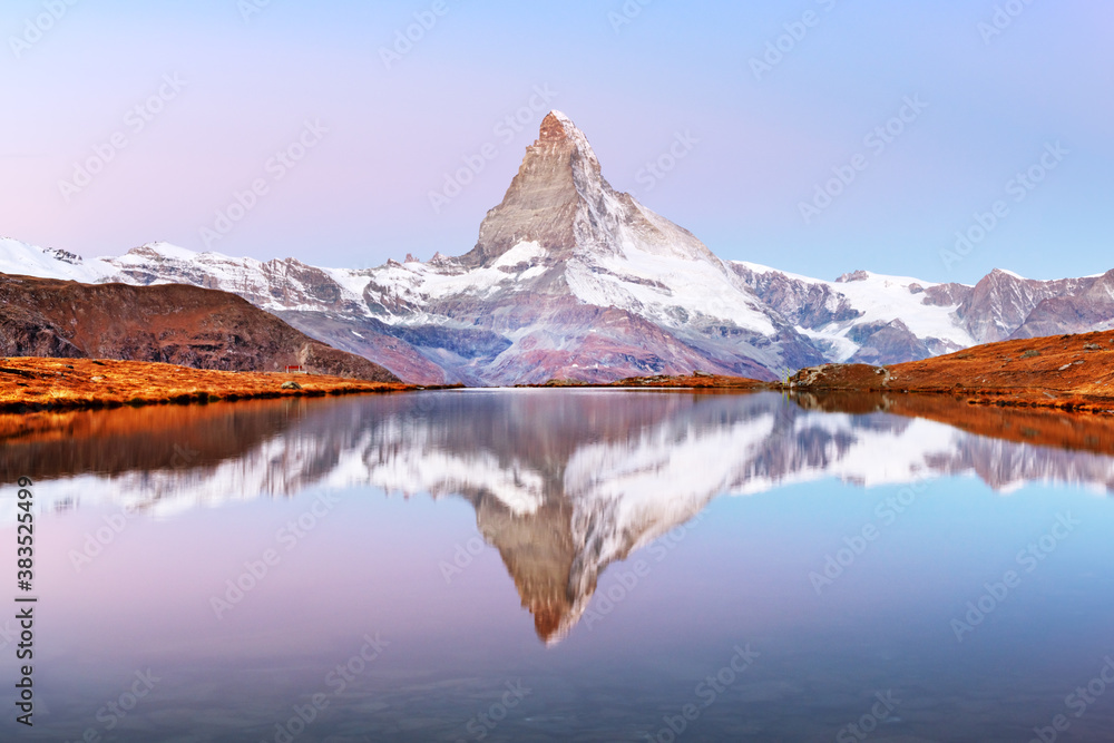 Picturesque landscape with colorful sunrise on Stellisee lake. Snowy Matterhorn Cervino peak with re