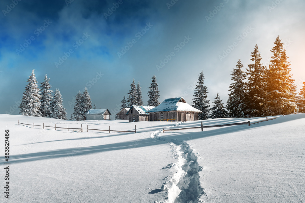 Fantastic winter landscape with wooden house in snowy mountains. Christmas holiday concept