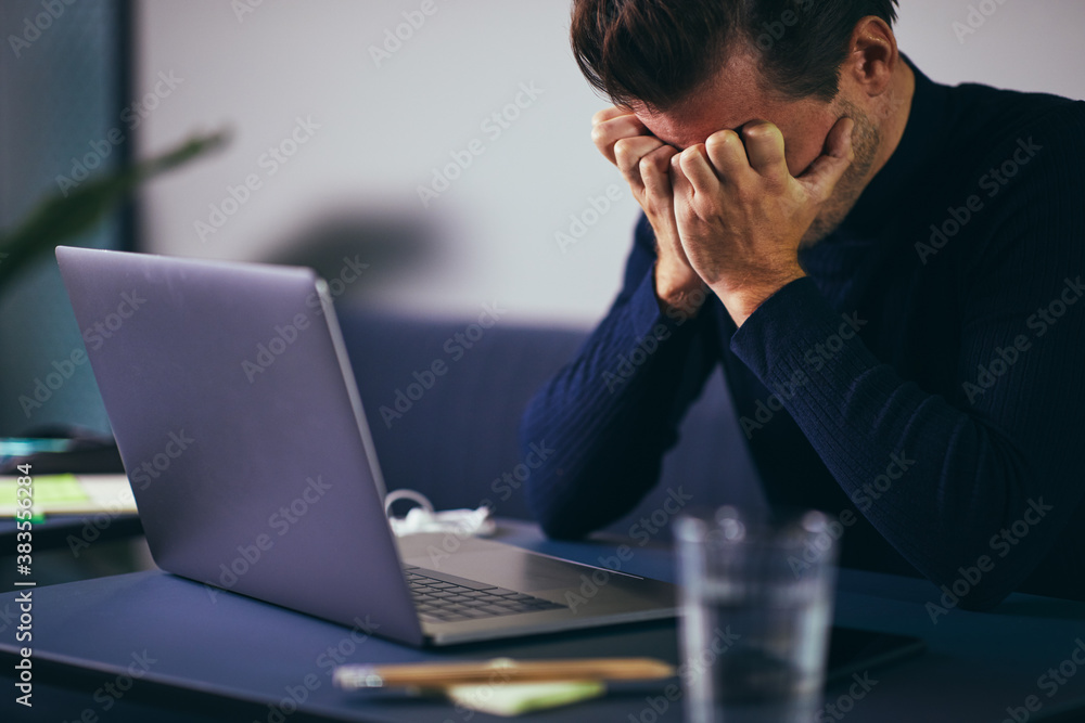 Businessman looking stressed out at his desk in an office