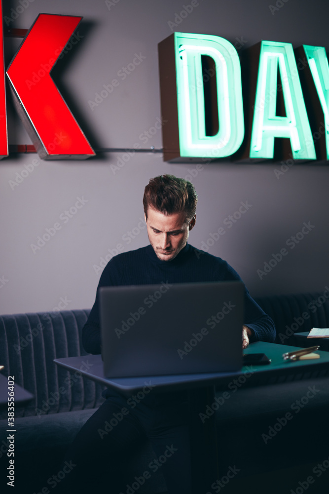 Young businessman sitting at an office table using a laptop