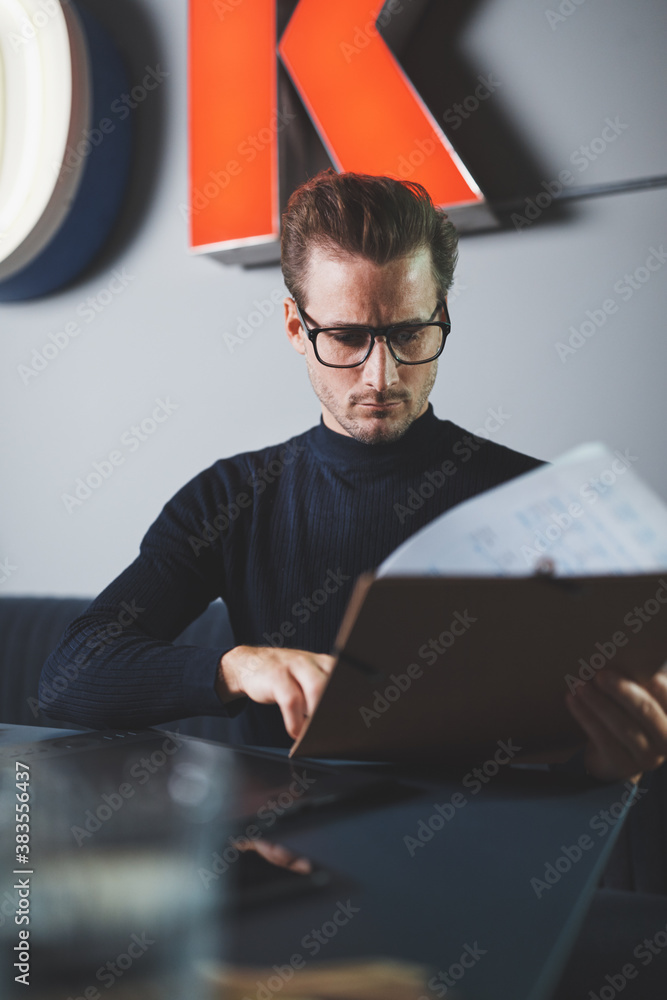 Businessman reading documents at his desk in a modern office