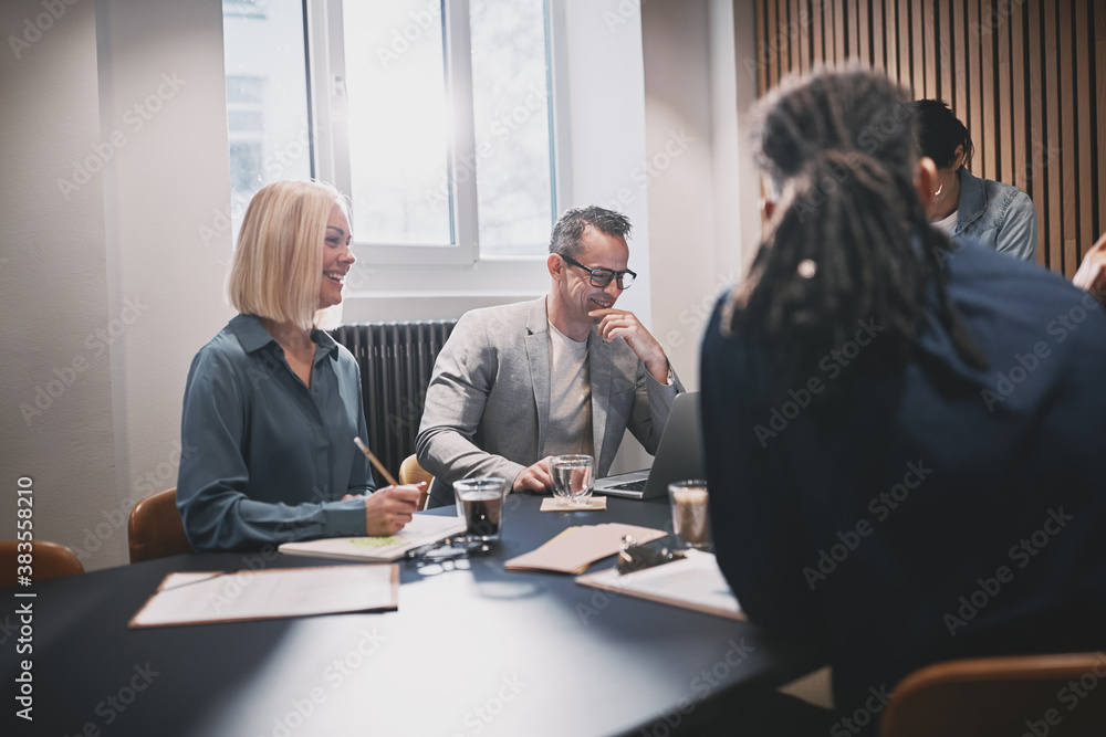 Smiling businesspeople working together around a boardroom table