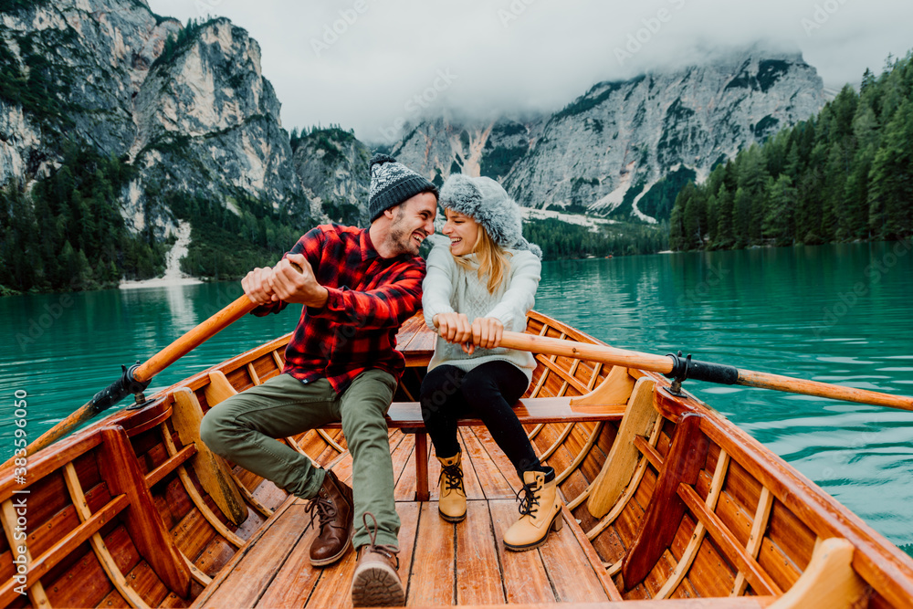 Titolo: Romantic couple on a boat visiting an alpine lake at Braies Italy. Tourist in love spending 