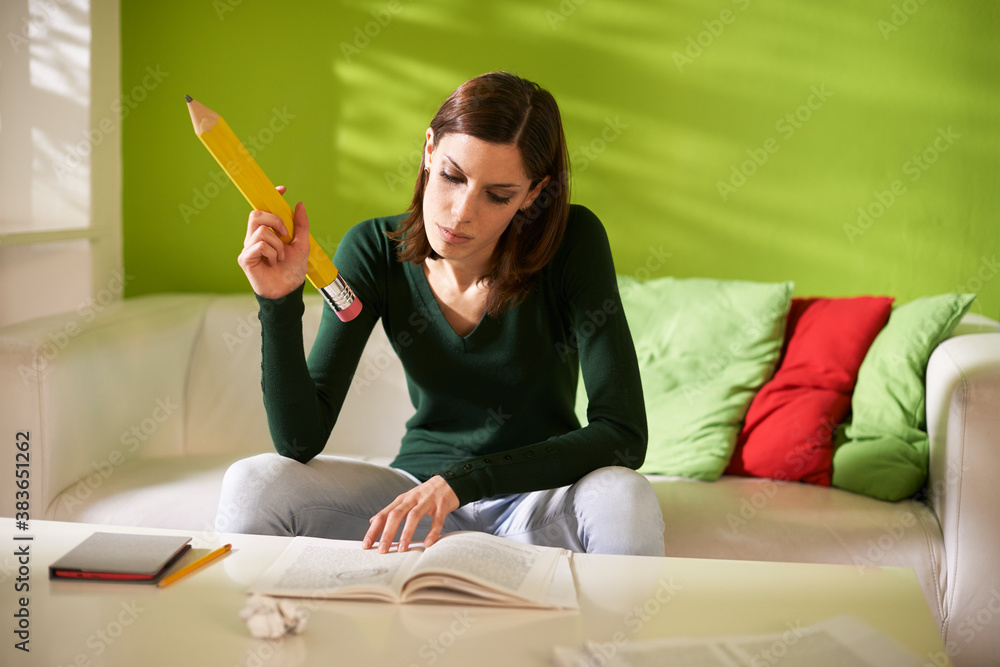 female student doing homeworks with big pencil