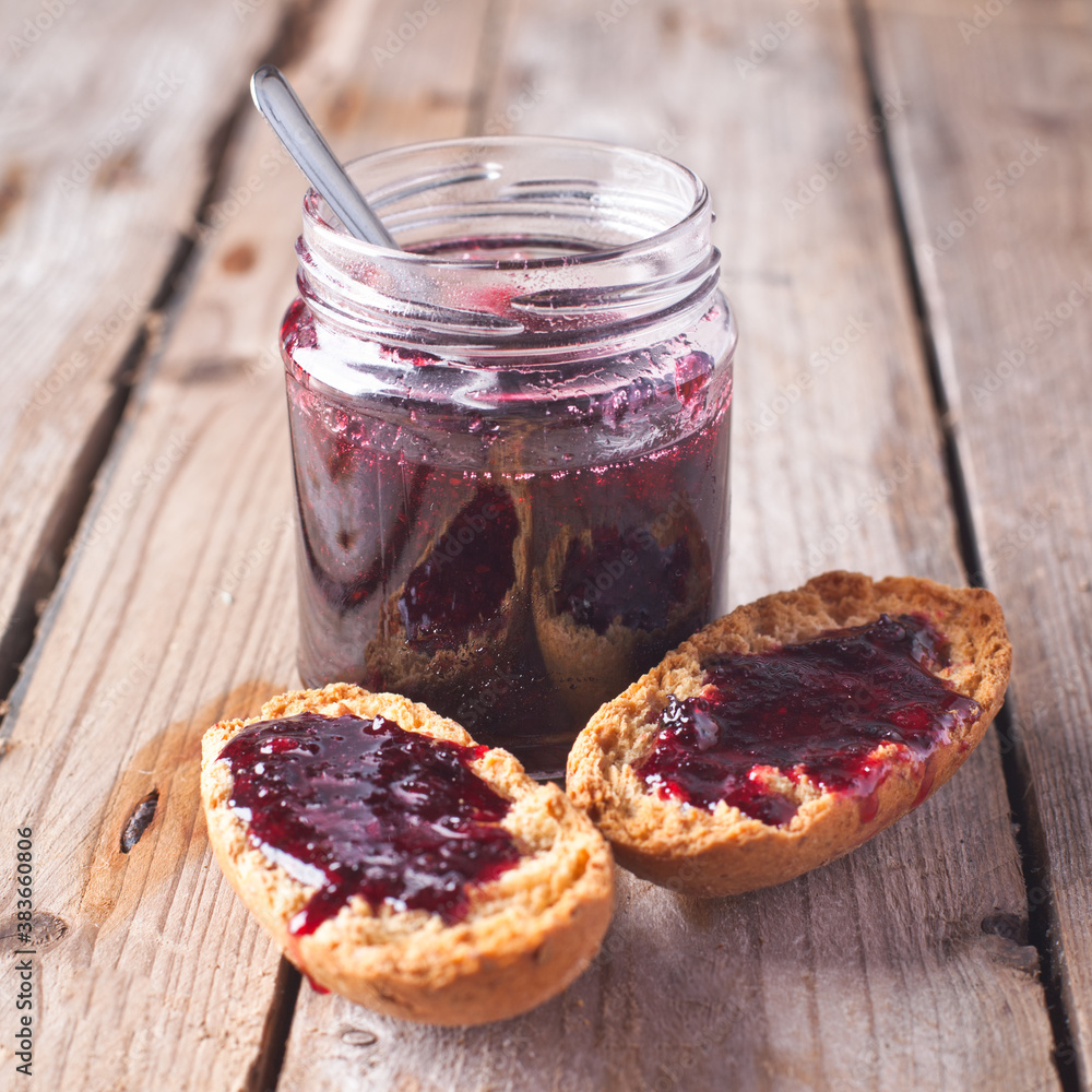 black currant jam in glass jar and crackers 