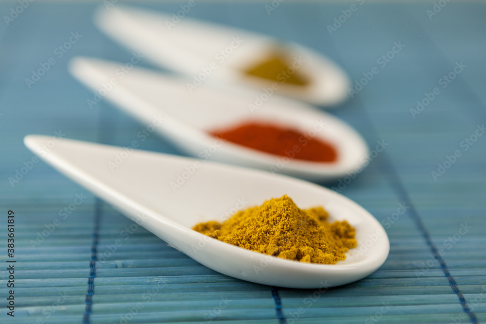 Dried ground spices in ceramic spoons