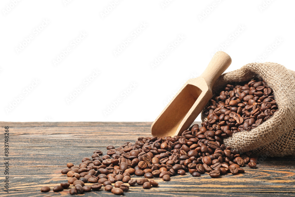 Bag with coffee beans on table against white background