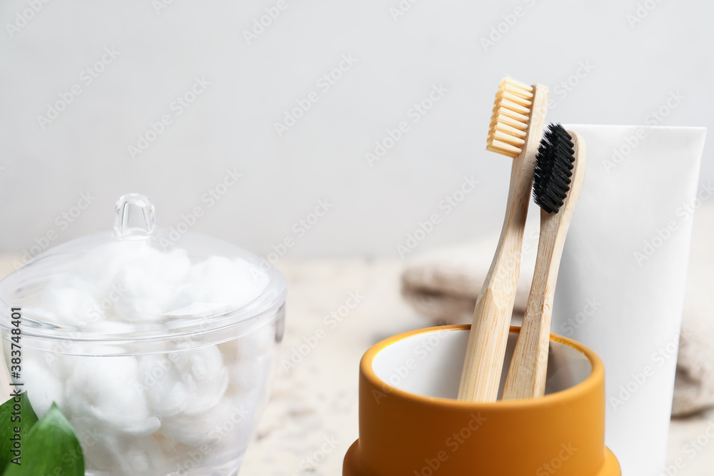 Cup with wooden tooth brushes in bathroom