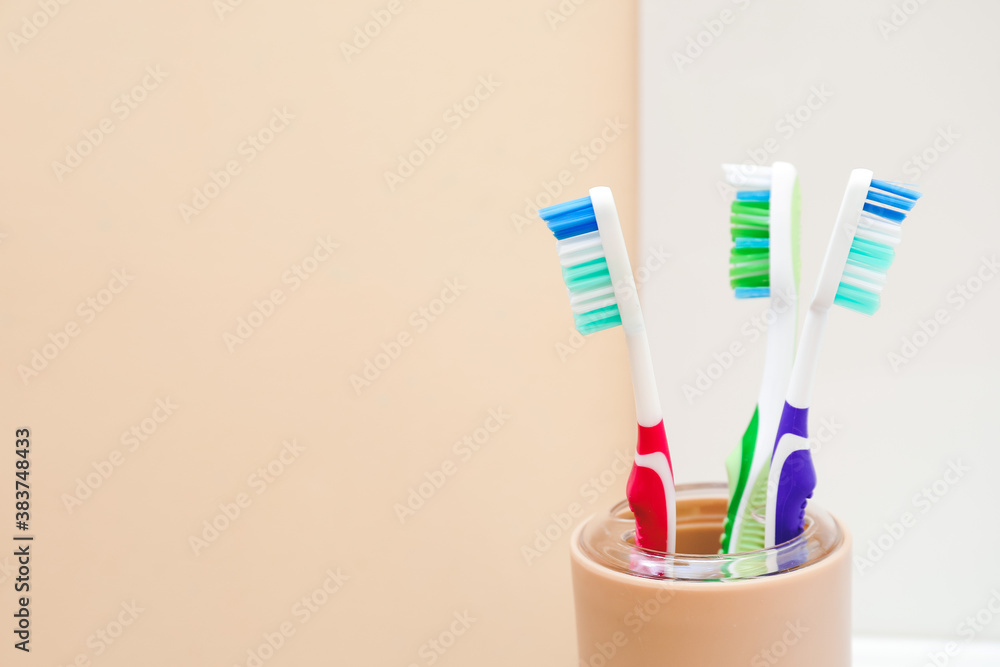 Cup with tooth brushes in bathroom