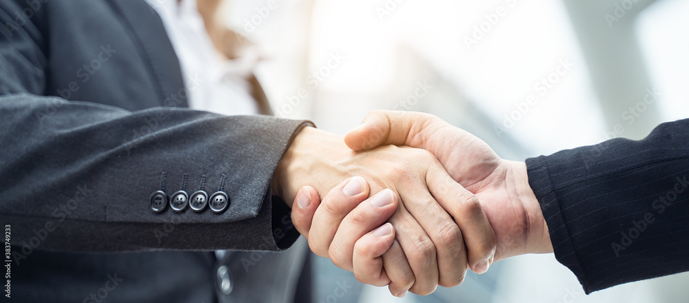 Asian businessmen making handshake in city with building background.