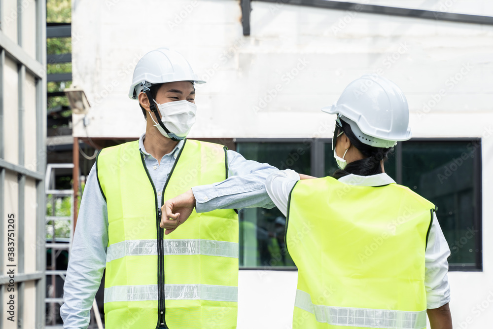 Asian young engineer man and woman greeting each other by elbow touch.