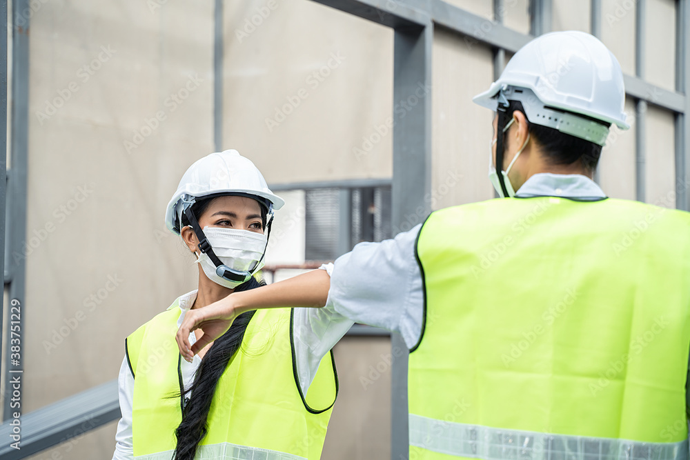 Asian young engineer man and woman greeting each other by elbow touch.