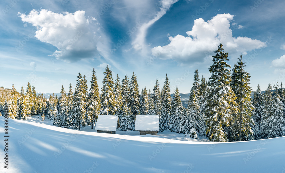 Fantastic winter landscape with wooden house in snowy mountains. Christmas holiday concept