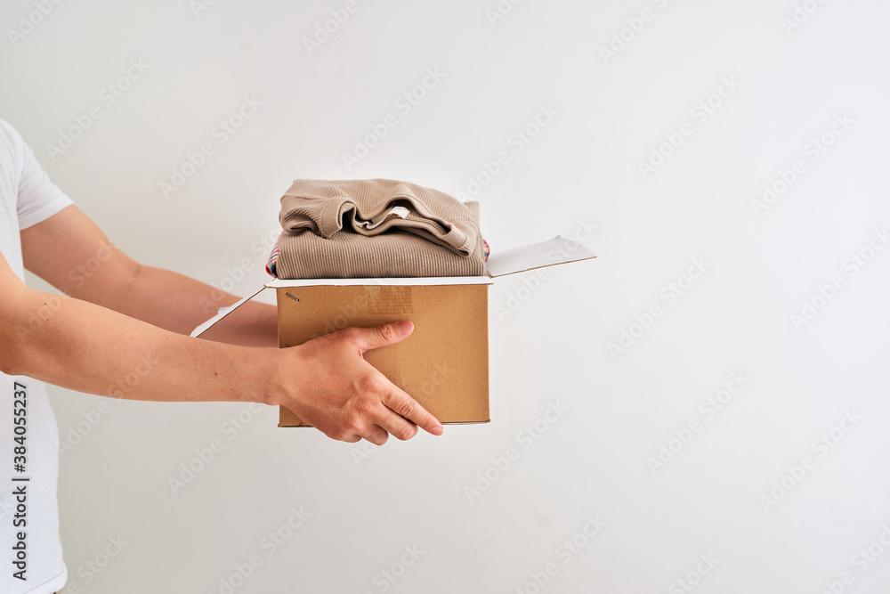 Man holding a clothes donate box. Donation concept.