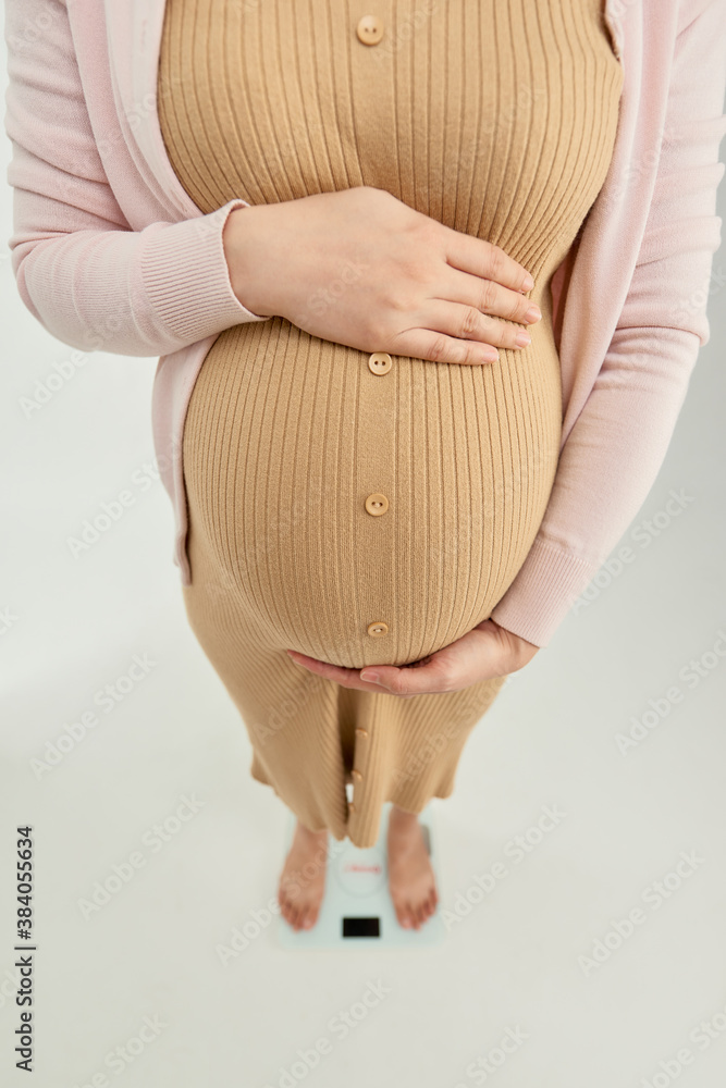 Pregnant woman standing on the scales - view from the top on the scales.