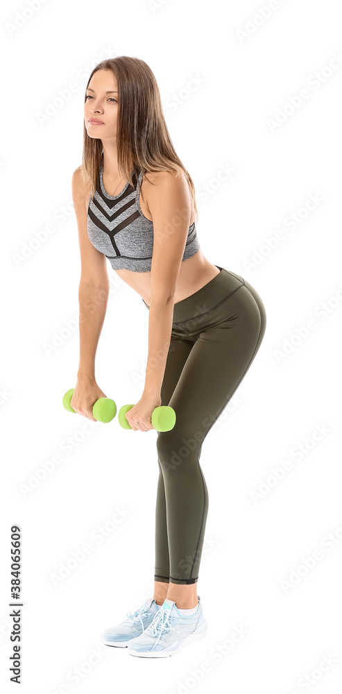 Sporty young woman with dumbbells on white background