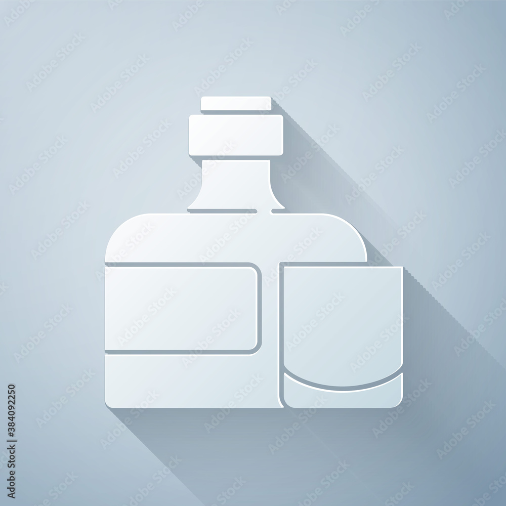 Paper cut Whiskey bottle and glass icon isolated on grey background. Paper art style. Vector.