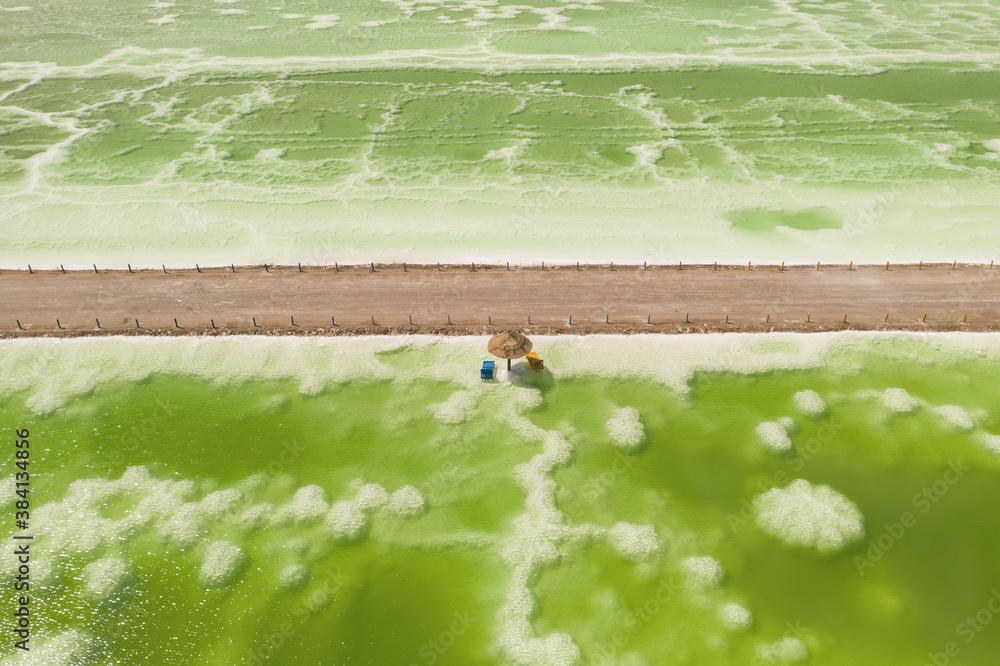 The green saline lake and beach umbrella, natural lake background.